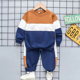 Colorblock kids tracksuit set in brown, white, and navy on display, featuring a cozy sweatshirt and joggers.